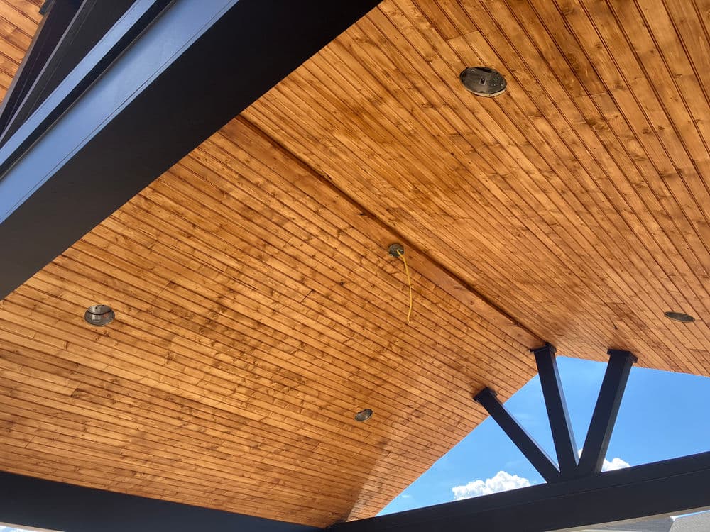 Exposed wood ceiling with lighting fixtures in modern architectural design.
