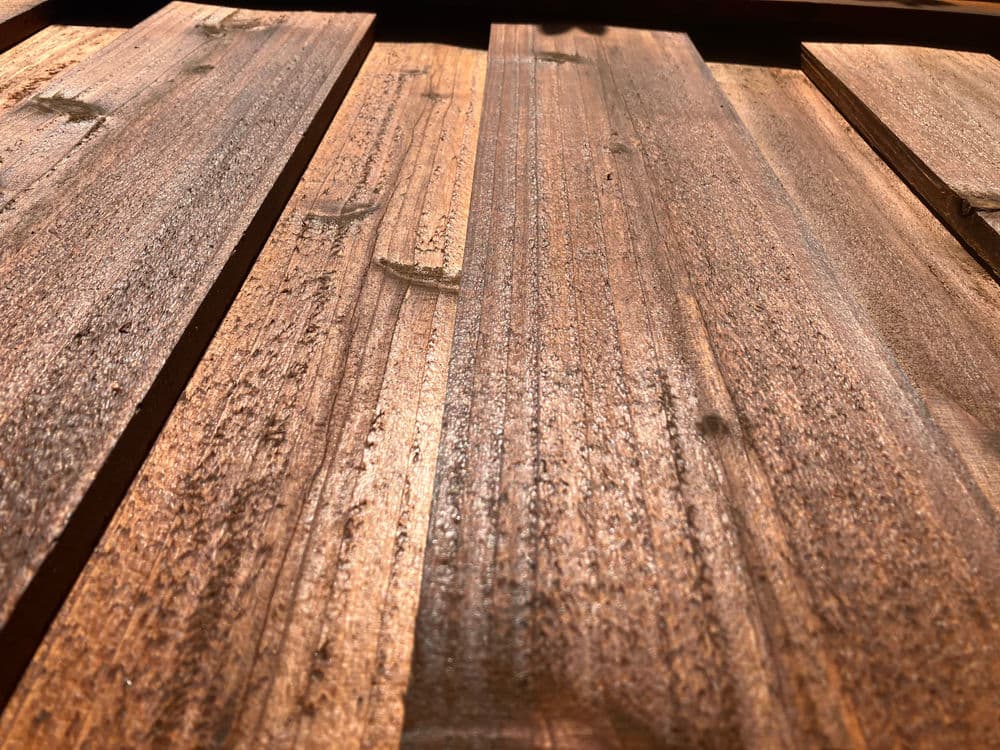 Close-up of polished wooden planks showing rich grain and warm tones in natural light.