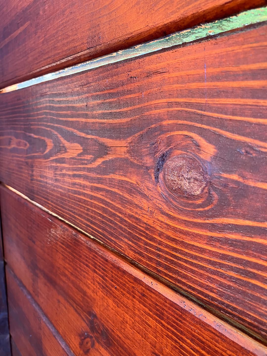 Close-up of rich, textured wooden planks with a warm, deep brown finish.